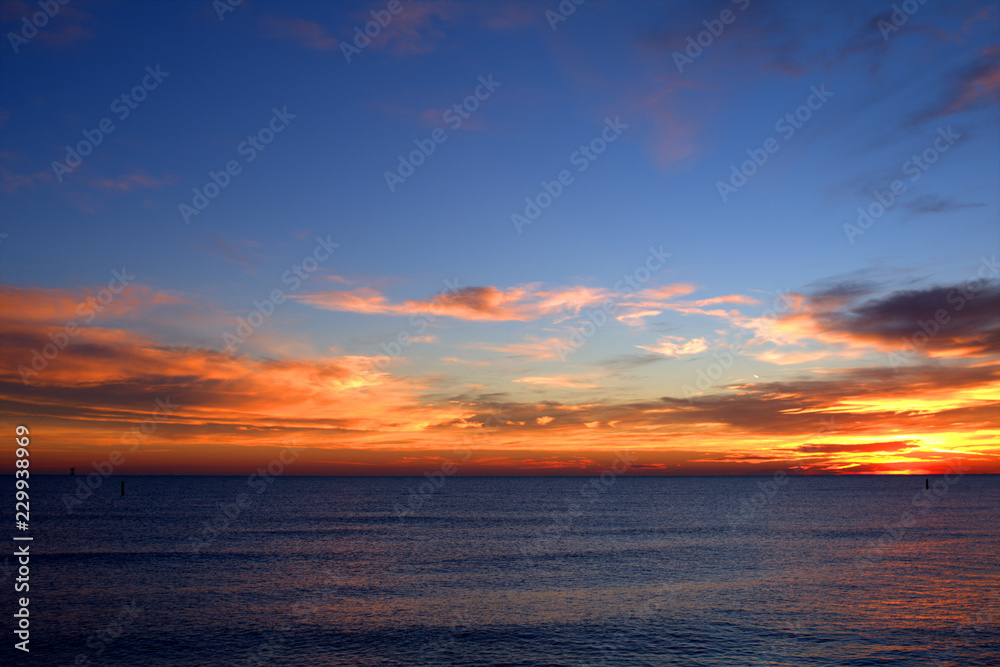 sunset over the sea,sky,clouds,view,calm,sunrise,nature,orange,blue,light,sunlight