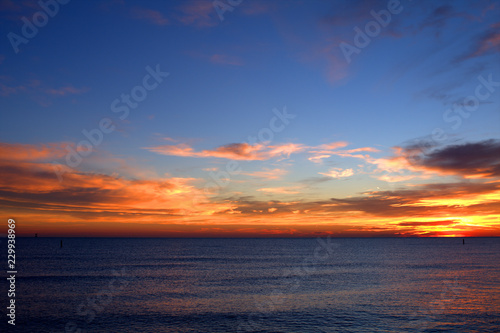 sunset over the sea,sky,clouds,view,calm,sunrise,nature,orange,blue,light,sunlight