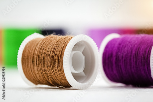 The roll of thread on background,show texture of brown color thread,needlework,craft,sewing and tailoring concept,blurry light around