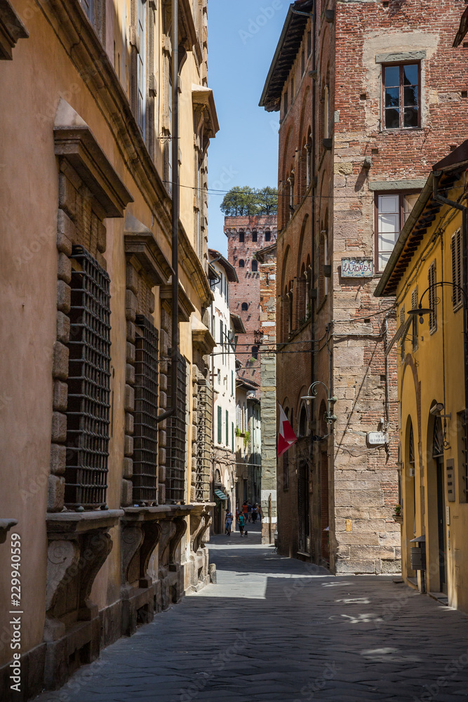 Lucca Italy July 4th 2015 : Narrow streets leading to the Guinigi tower in Lucca Tuscany