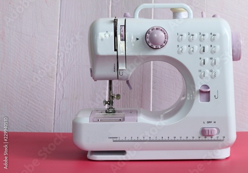Electric sewing machine on pink background