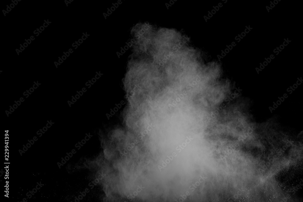 Bizarre forms of white powder explosion cloud against black background.White dust particles splash.