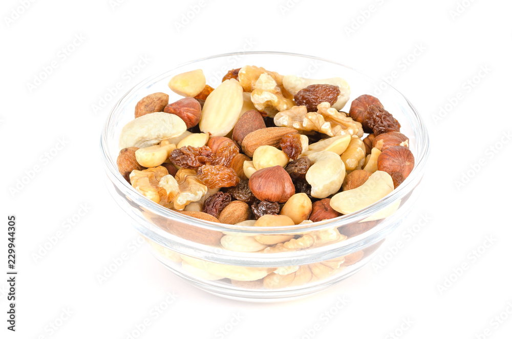 Student food in glass bowl. Student fodder. Snack mix of dried almonds, cashews, peanuts, walnuts, hazelnuts and raisins. Trail mix. Isolated macro food photo, closeup from above, on white background. Student food in glass bowl. Student fodder. Snack mix of dried almonds, cashews, peanuts, walnuts, hazelnuts and raisins. Trail mix. Isolated macro food photo, closeup from above, on white background.