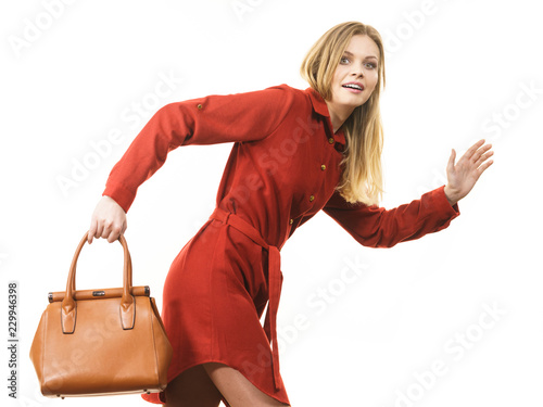 Female wearing red dress holding bag running