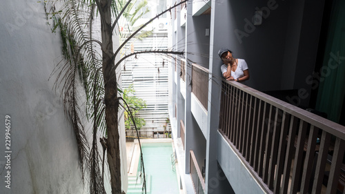 woman standing on balcony looking at photographer