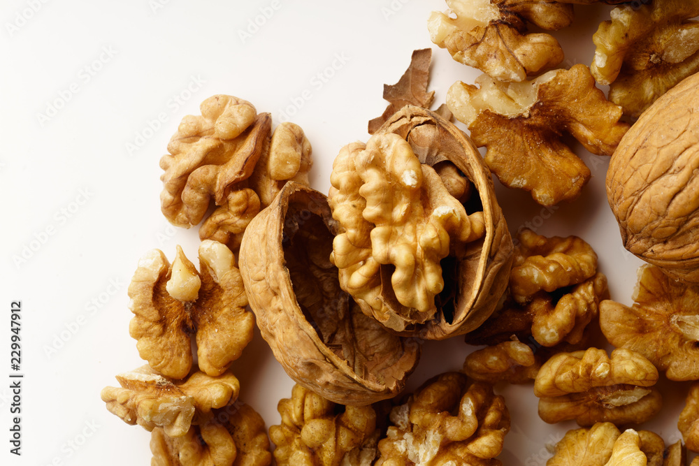 A heap of raw walnuts on white background isolated with copy space A heap of raw walnuts on white background isolated with copy space