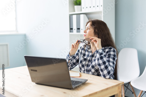 Working, business, technology and people concept - young woman watching something in window, relax after work.