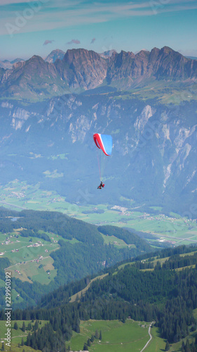 paraglider flying in the sky above the mountains of Switzerland