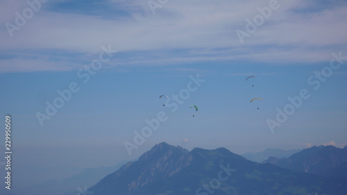 paragliders flying in the sky above the mountains of Switzerland © makasana photo
