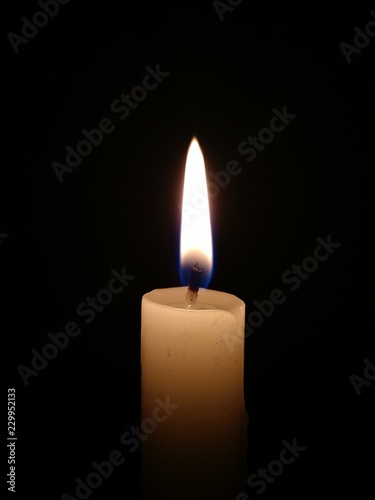 Candle burning brightly in the dark