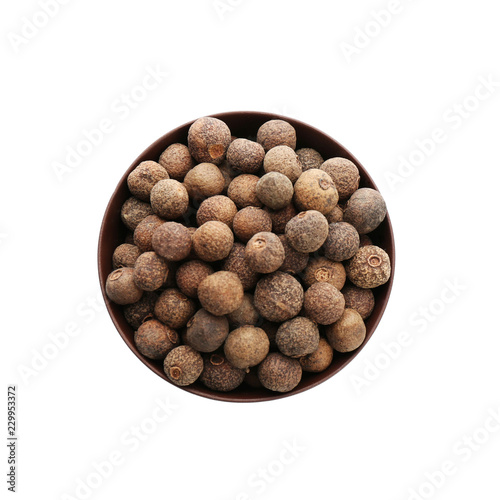 Bowl with allspice pepper grains on white background, top view