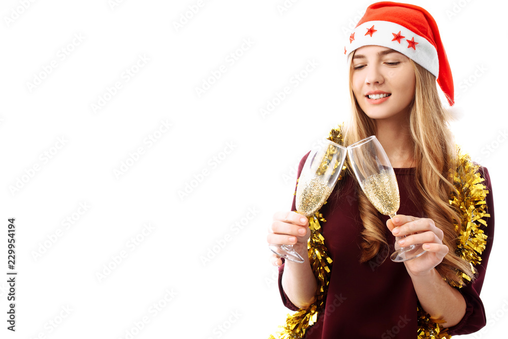 beautiful girl wearing a santa claus hat, in her hands, glasses of champagne, on a white background. beautiful girl wearing a santa claus hat, in her hands, glasses of champagne, on a white background.
