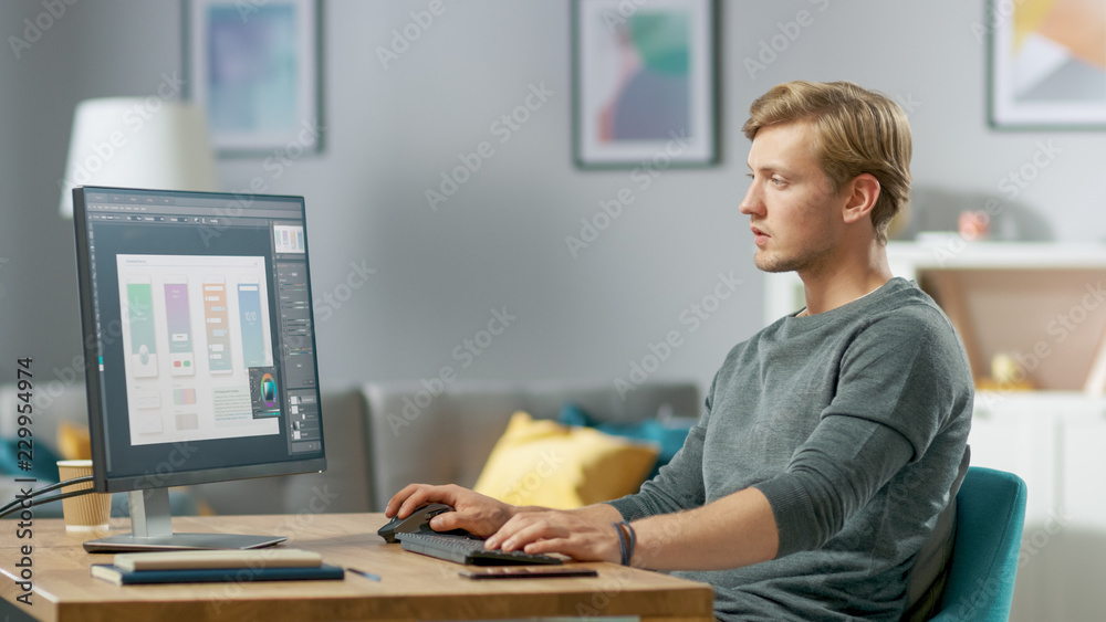 Handsome Focused Young Man Works on a UX / UI Mobile App Template, Uses ...