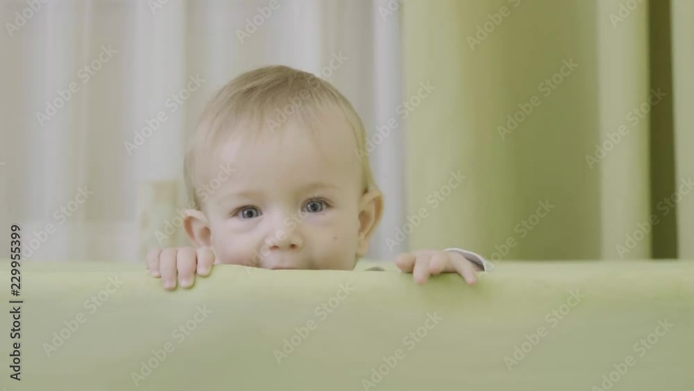 Sweet baby portrait at crib margin, child safety Sweet baby portrait at crib margin, child safety