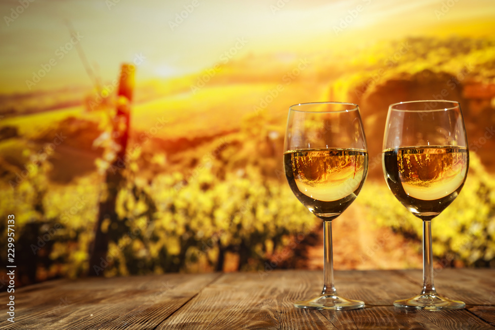 Two glasses with wine on a wooden table in an autumn setting   