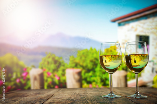 Two glasses with wine on a wooden table in an autumn setting   