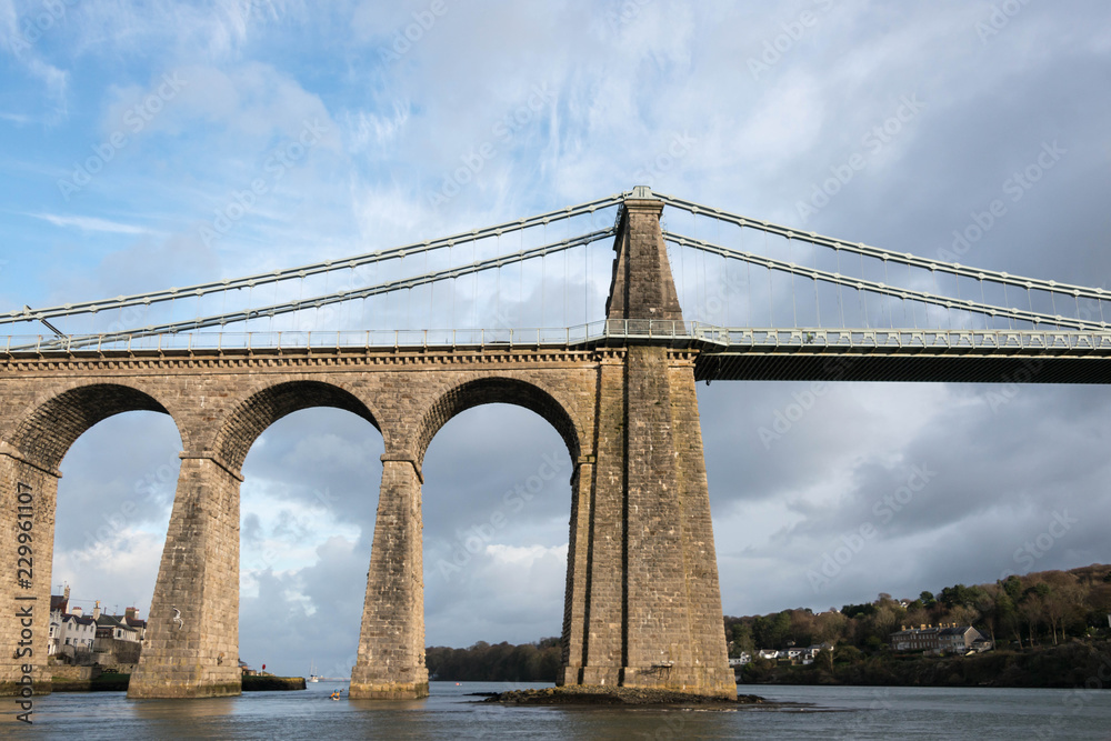 Naklejka premium A view of the historic Menai suspension bridge spanning the Menai Straits, Gwynnedd, Wales, UK.