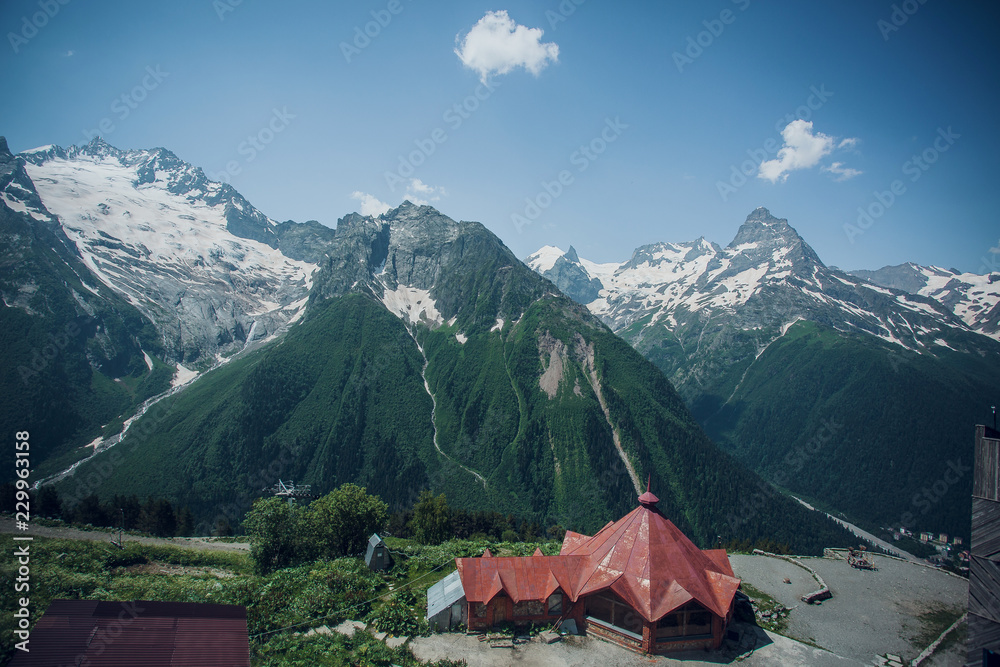 Caucasus mountain range in summer, snow-capped peaks, Sunny day, tent in the foreground