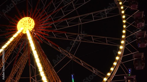 Beautiful flashing lights blurred illumination colorful bokeh of huge ferris wheel at amusement park at night background
