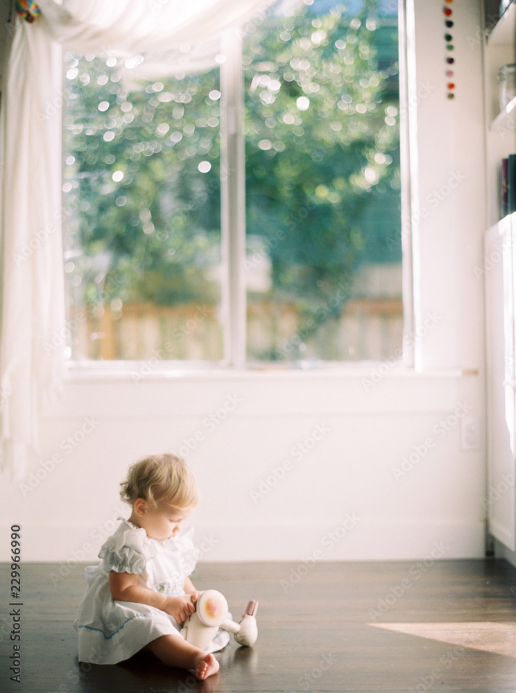 baby in the sunlight playing with wooden toy baby in the sunlight playing with wooden toy