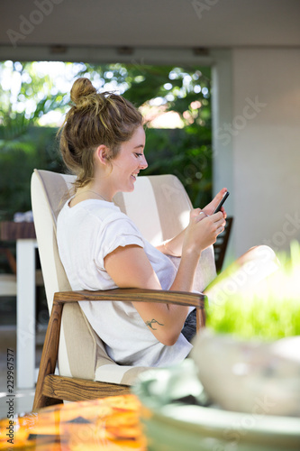 Young beautiful woman using her phone at home