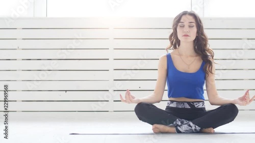 Yoga and home workouts concept. Young woman meditates while practicing yoga indoors photo