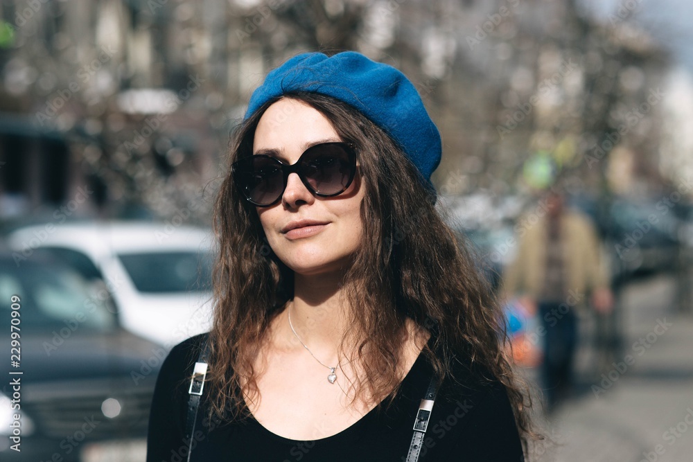 Young woman in blue beret and sunglasses in the city. winter clothes . elegant image for everyday life. Young woman in blue beret and sunglasses in the city. winter clothes . elegant image for everyday life.