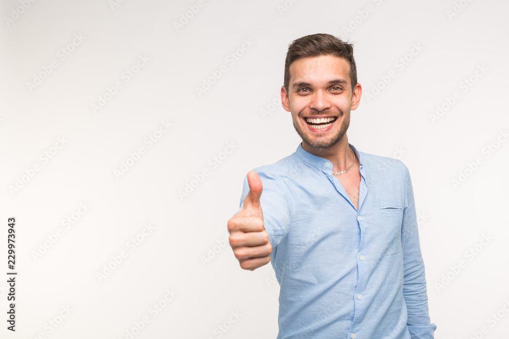 Gesture and people concept - Handsome man with smile showing thumb up on white background with copy space Gesture and people concept - Handsome man with smile showing thumb up on white background with copy space