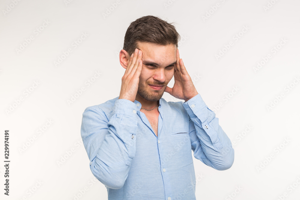 Portrait of a young handsome thinking man and feels a headache on white background Portrait of a young handsome thinking man and feels a headache on white background