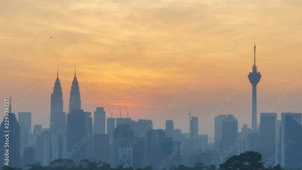 Two landmark buildings of Kuala Lumpur, the Petronas Twin Tower and the KL Tower silhouetted against the morning sky. Pan Left Two landmark buildings of Kuala Lumpur, the Petronas Twin Tower and the KL Tower silhouetted against the morning sky. Pan Left