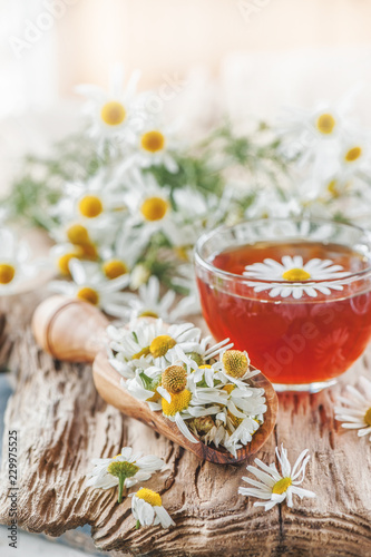 A clear Cup of medicinal chamomile tea on an old wooden table. Health and healthy lifestyle concept