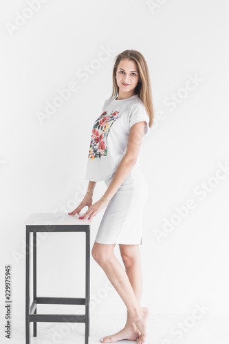 Portrait of a young stylish brunette girl posing for the camera on white background