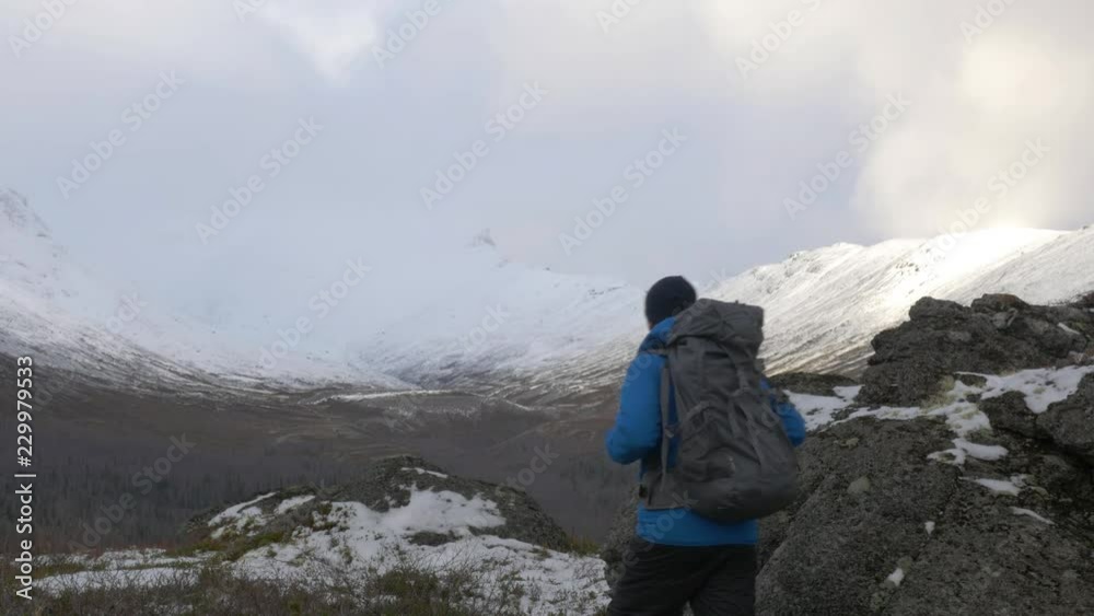 A man travels in a mountain park with a backpack. A man travels in a mountain park with a backpack.