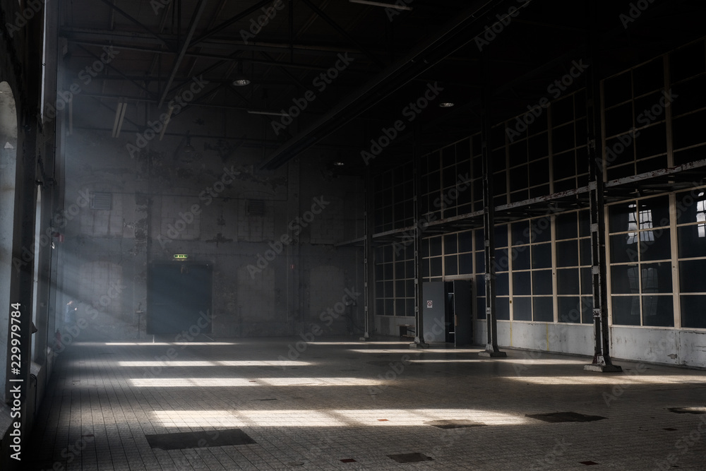 Sunlight shining throuh the windows of an old abandoned industrial warehouse building