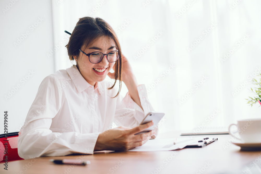 Shot of an attractive businesswoman working on smart phone in her workstation. Shot of an attractive businesswoman working on smart phone in her workstation.