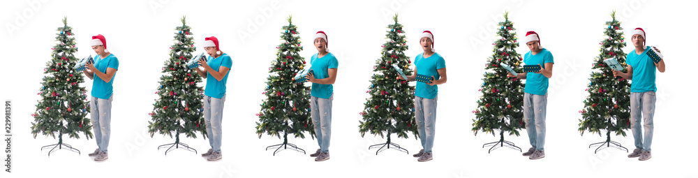 Young man decorating christmas tree isolated on white Young man decorating christmas tree isolated on white