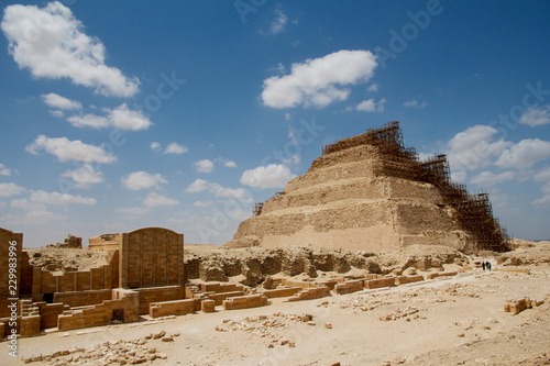 The famous Step Pyramid of Djoser in Sakkara (Saccara) part of the Giza Plateau and necropolis, shown with scaffolding and deep blue sky