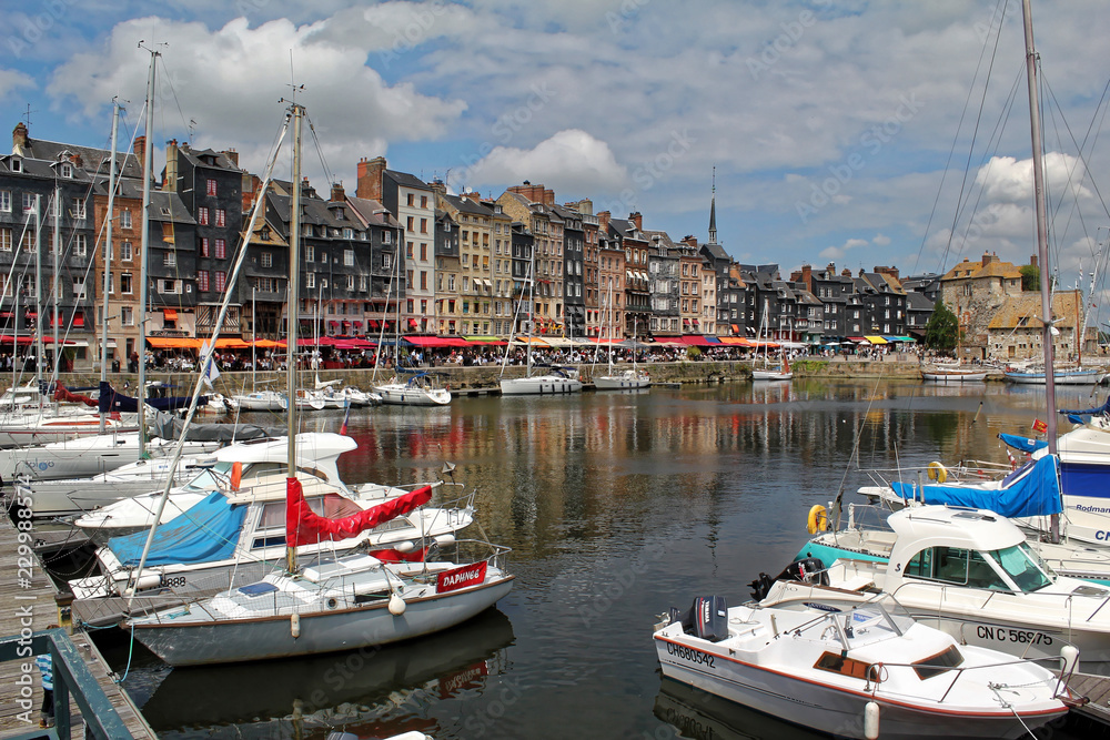 Honfleur, France - July 10 2017: Honfleur harbour in Normandy, France. Color houses and their reflection in water