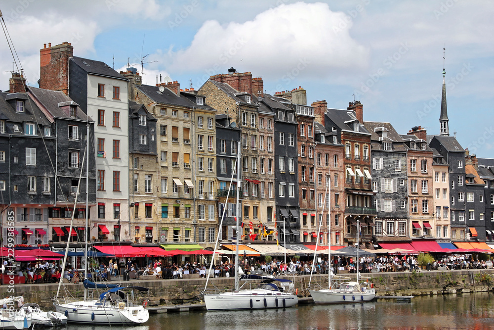 Honfleur, France - July 10 2017: Honfleur harbour in Normandy, France. Color houses and their reflection in water