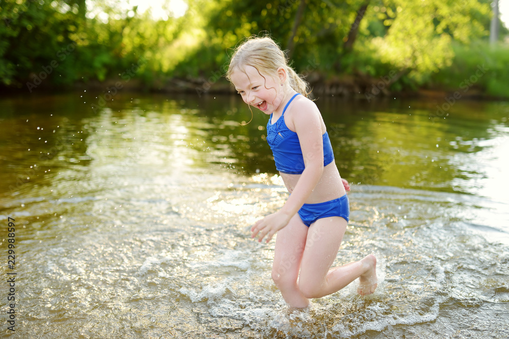 little girl sexy Cute little girl wearing swimsuit playing by a river on hot summer day. Adorable child having fun outdoors during summer vacations. Stock 写真 | Adobe Stock