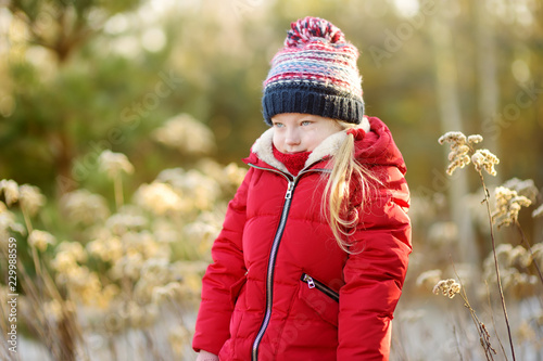 Fotografie Adorable little girl having fun in beautiful winter park