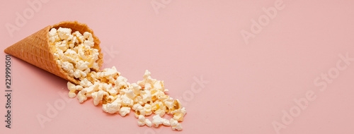 Popcorn in ice cream cones on pink background