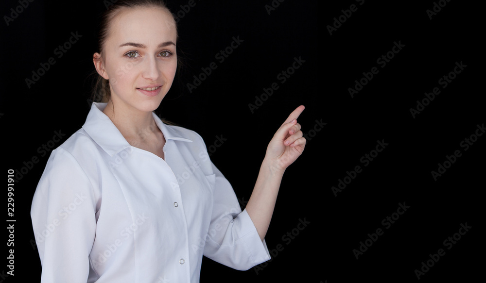 Front view of a young intellectual doctor on a black background. Doctor showing on text space Front view of a young intellectual doctor on a black background. Doctor showing on text space