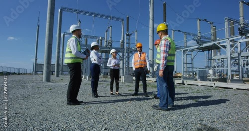 Wallpaper Mural Group of adult diverse men in hardhats gathering on transformer platform of solar electrical plant having discussion Torontodigital.ca