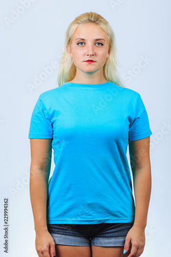 Young cute blonde girl stands straight
