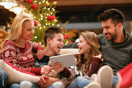 family  Christmas  x-mas  technology and people concept - watching funny video on digital tablet.