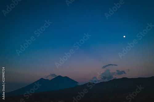 Moon over Fuego and Acatenango volcanoes at sunrise in Guatemala