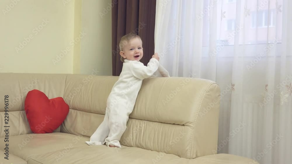 Little child plays with the curtain at home Little child plays with the curtain at home