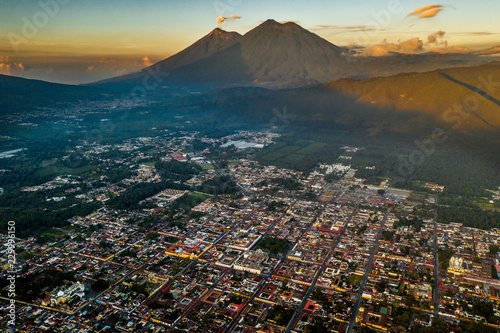 Aerial view of Antigua Guatemala at sunrise with volcanoes