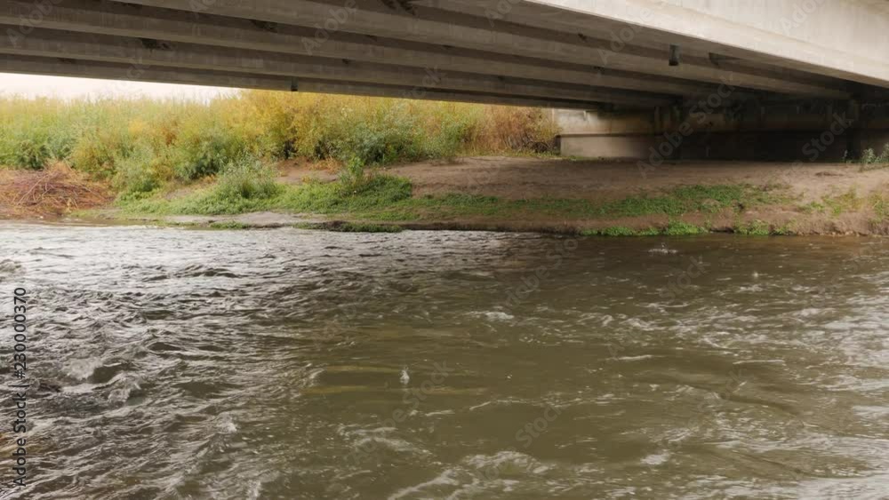 Under a large bridge in the rain. Under a large bridge in the rain.